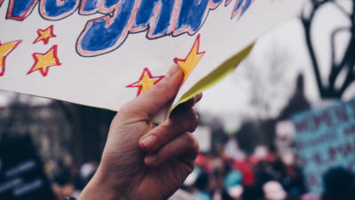 Close-up of hand holding sign in protest march
